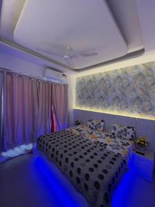 a bedroom with a black bed with blue lighting at Happy Stay expo in in Greater Noida