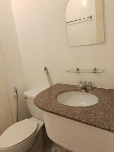 Un baño con inodoro, lavabo y espejo. en Albergo Hotel Unit near Wright Park, The Mansion, Minesview & Botanical Garden, en Baguio