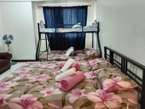 Un dormitorio con una cama con flores rosas. en Albergo Hotel Unit near Wright Park, The Mansion, Minesview & Botanical Garden, en Baguio