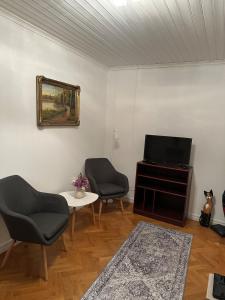 a living room with two chairs and a television at Grevgatan 4 Apt 1101 in Eksjö