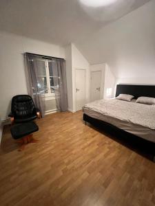 a bedroom with a bed and a chair in it at Grevgatan 4 Apt 1101 in Eksjö