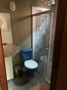 a bathroom with a blue toilet and a shower at Casinha da Mila in Piatã