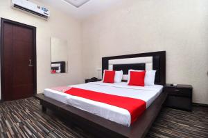 a bedroom with a large bed with red pillows at Hotel O B1 in Kartārpur +23 photos