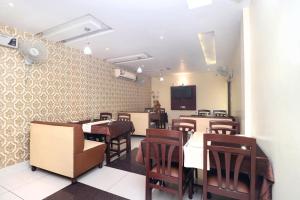 a dining room with tables and chairs and a tv at Hotel O B1 in Kartārpur