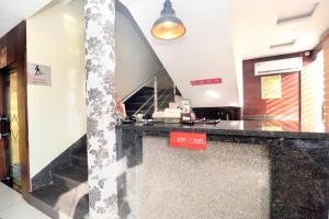 a lobby with a black counter and a mirror at Hotel O B1 in Kartārpur