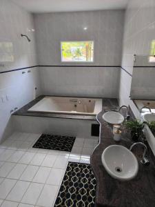 a bathroom with a tub and a sink at Farol dos Coqueiros in Angra dos Reis