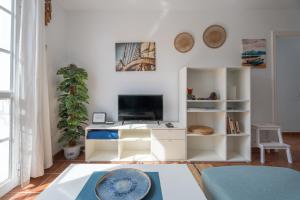 a living room with white furniture and a flat screen tv at Two bedroom apartment with sea view in Los Abrigos in Los Abrigos