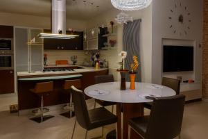 a kitchen with a table and chairs and a clock on the wall at Suite Gravina + box auto privato in Gravina in Puglia