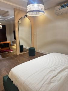 een slaapkamer met een bed en een grote spiegel bij Najdeh Suite, our goal is to make you comfortable in Jeddah