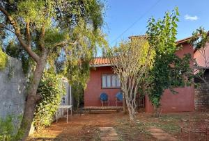 a red house with trees in front of it at Casinha da Mila in Piatã