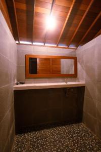une salle de bain avec un lavabo et un miroir dans l'établissement Mangrove Beach Hut, à Nusa Lembongan