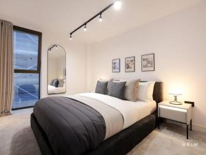 a bedroom with a large bed and a large window at Pappilo at The Heim Residences in Manchester