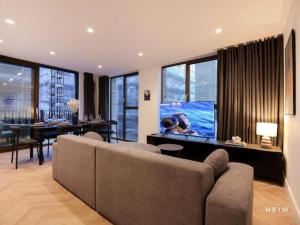 a living room with a couch and a flat screen tv at Pappilo at The Heim Residences in Manchester