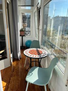 a table and chairs in a room with a window at Kasa Reina HT LSS00215 in Donostia-San Sebastián