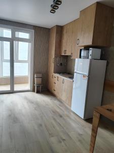 a kitchen with a white refrigerator and a window at Апартаменты у новому будинку біля Либідь Плази-Ощадбанк in Khmelʼnytsʼkyy +11 photos