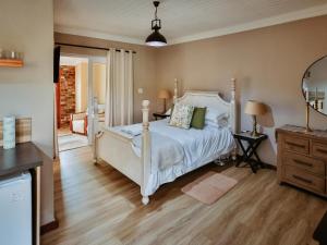 une chambre avec un lit blanc et une commode dans l'établissement Franschhoek Farm Cottages, à Swiss Farm 46 autres photos