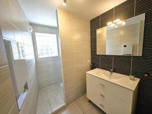 ein Badezimmer mit Waschbecken und Spiegel in der Unterkunft Résidence Brise de Mer - 2 in Port Nayalo