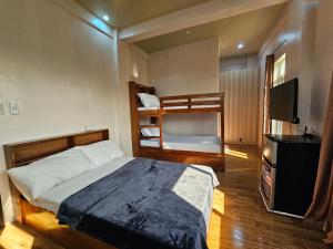 a bedroom with a bed and a bunk bed at Gloria Beach House - Baler in Baler