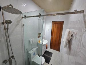 a bathroom with a shower and a toilet and a sink at Gloria Beach House - Baler in Baler +21 photos