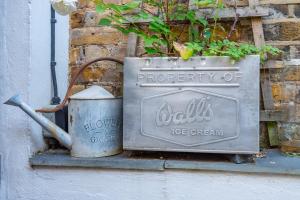 a metal sign on a ledge with a trash can at Charming 1BD Flat with Garden Wimbledon Village in London