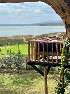 Un hombre acostado en una cama junto a una masa de agua en TREE HOUSE Lodge, en Gilgil