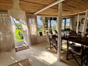 a dining room with a table and some windows at TREE HOUSE Lodge in Gilgil