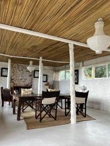 a dining room with a wooden ceiling and a table and chairs at TREE HOUSE Lodge in Gilgil