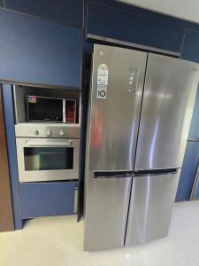 a kitchen with a stainless steel refrigerator and an oven at 팔레드시즈 콘도- Pale de CZ Condo in Busan