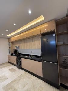 a kitchen with a black refrigerator and a dishwasher at Appartement a Malabata hills in Tangier +3 photos