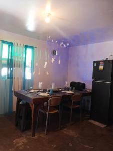 a kitchen with a table with chairs and a refrigerator at Alegreya Homestay + Cafe in General Luna