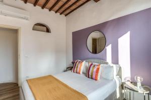 a bedroom with a bed with a mirror on the wall at Santa Maria Dreaming Rooftop in Pisa