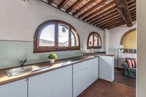 a kitchen with white cabinets and a sink and a window at Santa Maria Dreaming Rooftop in Pisa +49 photos