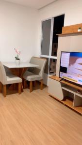a living room with a table and a laptop computer at Aconchego da day in Aracaju
