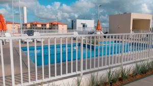 a white fence next to a swimming pool at Aconchego da day in Aracaju