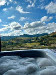 a bath tub with a view of the clouds at Chalet Vinícola D'alture 6 pessoas in São Joaquim