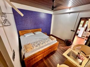 a bedroom with a bed with a blue wall at Ri Tngen - A slice of nature by the Umiam lake! in Borpāni