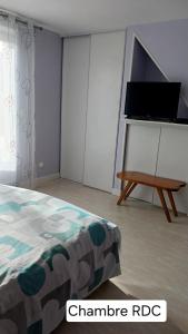 a bedroom with a bed and a tv and a table at Chez Barnar in Arvert +10 photos