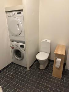 a bathroom with a washing machine and a toilet at 2 rok i Söderfors wärdshus in Söderfors