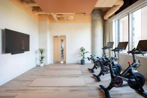 ein Fitnessraum mit Fahrrädern und einem Flachbildfernseher in der Unterkunft StayCozy in Croydon in Croydon