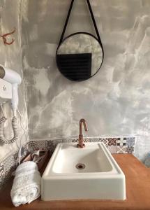 a bathroom with a sink and a mirror on the wall at Suítes da Sereia in Cananéia
