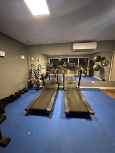 a gym with rows of treadmills in a room at Hotel Bossa Nova Cabo Frio Passagem flat com varanda in CFB
