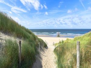 WestermientにあるPretty Holiday Home in De Koog Texel with Gardenの塀と海の付いた海岸への道