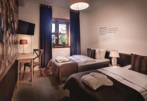 a hotel room with two beds and a desk and a table at Högberga Gård in Lidingö +19 photos