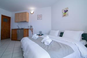 two beds in a room with towels on them at Malvasia Corner Studios - ex Romeo's House in Monemvasia