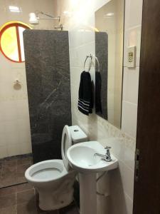 a bathroom with a white toilet and a sink at Pousada Flat Royal - Flat 03 in Itapecerica