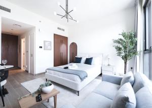 a living room with a bed and a couch at StayShort - Town Square sleeps 2 in Great Location in ‘Ūd al Bayḑāʼ