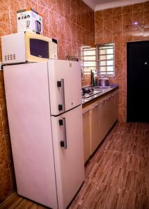 a white refrigerator with a microwave on top of it in a kitchen at Citadel Royal apartment in Lekki