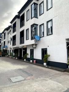 a white building with black windows and a street at Citadel Royal apartment in Lekki
