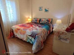 una camera da letto con un letto con un piumone colorato di Atlantis Apartment Trieste a Trieste