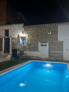 a swimming pool in front of a house at night at Casa Antonia in La Puebla de Montalbán